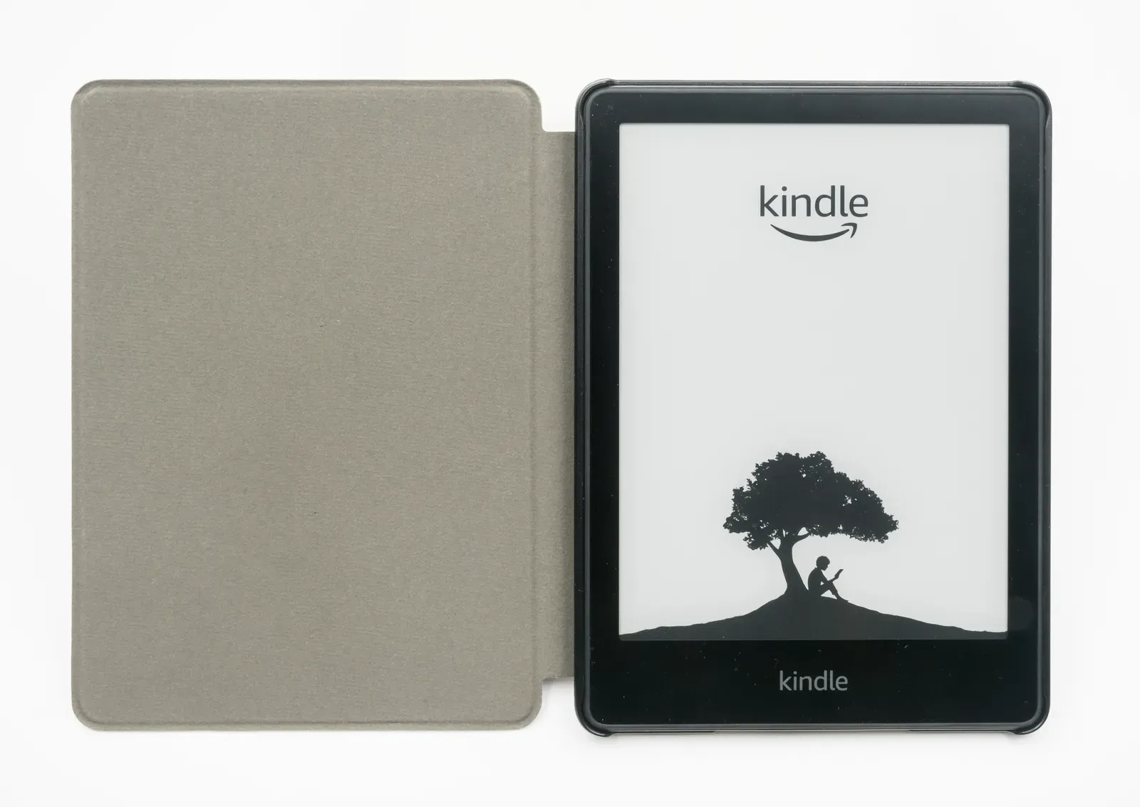 A Kindle Paperwhite next to its fabric cover. This is the 2023 model; the 2024 version looks almost the same